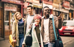 Amigos multirraciais felizes que andam na pista do tijolo em Shoreditch imagem de stock royalty free Amigos multirraciais felizes que andam na pista do tijolo em Shoreditch imagem de stock royalty free
