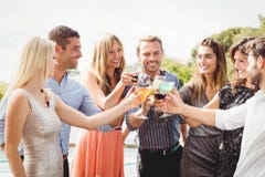 Amigos novos felizes que têm bebidas imagens de stock royalty free Amigos novos felizes que têm bebidas imagens de stock royalty free