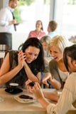 Amigos que olham fotografias e que riem o café imagem de stock Amigos que olham fotografias e que riem o café imagem de stock