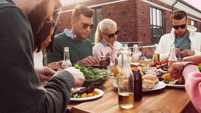 Amigos que tienen partido de la cena o del Bbq en tejado Amigos que tienen partido de la cena o del Bbq en tejado