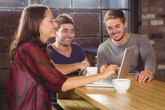 Amis de sourire ayant le café ensemble et regarder l'ordinateur portable images stock Amis de sourire ayant le café ensemble et regarder l'ordinateur portable images stock