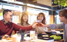 Amis des jeunes grillant et mangeant dans le restaurant images stock Amis des jeunes grillant et mangeant dans le restaurant images stock