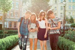 Amis des jeunes marchant dans la ville, un groupe d'adolescents parlant souriant ayant l'amusement dans la ville Amitié et les ge image stock Amis des jeunes marchant dans la ville, un groupe d'adolescents parlant souriant ayant l'amusement dans la ville Amitié et les ge image stock