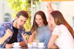 Amis enthousiastes célébrant le contenu de observation de téléphone de bonnes nouvelles image stock Amis enthousiastes célébrant le contenu de observation de téléphone de bonnes nouvelles image stock