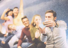 Amis heureux prenant un selfie de photo utilisant leur caméra mobile de smartphone se reposant dans un souterrain image libre de droits Amis heureux prenant un selfie de photo utilisant leur caméra mobile de smartphone se reposant dans un souterrain image libre de droits