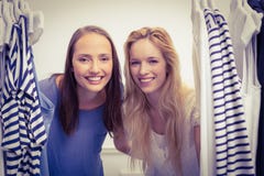 Amis heureux regardant par le support de vêtements Photo stock Amis heureux regardant par le support de vêtements Photo stock