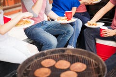Amis mangeant des hamburgers à un barbecue photographie stock Amis mangeant des hamburgers à un barbecue photographie stock