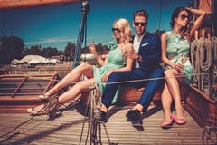 Amis riches élégants ayant l'amusement sur un yacht de luxe images libres de droits Amis riches élégants ayant l'amusement sur un yacht de luxe images libres de droits