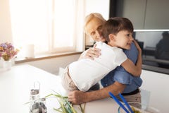 Amo a mi nieto El viejo hombre abraza a su nieto, que se sienta en la encimera de la cocina Imagenes de archivo Amo a mi nieto El viejo hombre abraza a su nieto, que se sienta en la encimera de la cocina Imagenes de archivo