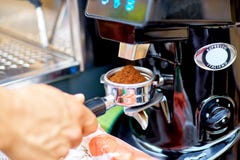 Amoladora de café que muele los granos de café recientemente asados en un coff Fotografía de archivo libre de regalías Amoladora de café que muele los granos de café recientemente asados en un coff Fotografía de archivo libre de regalías