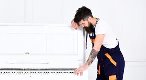 Amusement au travail Moteur beau jouant le pianoforte d'isolement sur le fond blanc Type barbu de vue de côté se penchant sur le Images stock Amusement au travail Moteur beau jouant le pianoforte d'isolement sur le fond blanc Type barbu de vue de côté se penchant sur le Images stock