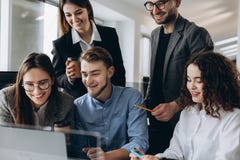 Analyzing fresh data. Group of young confident business people discussing new project and smiling while spending time in the stock photos Analyzing fresh data. Group of young confident business people discussing new project and smiling while spending time in the stock photos