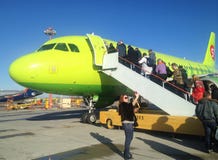 Passengers climb the ladder to the plane of the Siberian Airlines S7 royalty free stock images Passengers climb the ladder to the plane of the Siberian Airlines S7 royalty free stock images