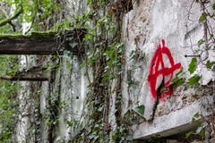 The `Anarchy` symbol graffitied in a ruined stock image The `Anarchy` symbol graffitied in a ruined stock image