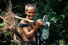 elderly senior khmer man walking home from his farm with some roots and his tool in his hand stock photos elderly senior khmer man walking home from his farm with some roots and his tool in his hand stock photos