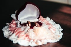 Anillos de bodas en una caja y una liga de la novia en la tabla de madera imagen de archivo Anillos de bodas en una caja y una liga de la novia en la tabla de madera imagen de archivo