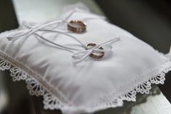 Anneaux les épousant d'or sur l'oreiller de satin dans l'église images libres de droits Anneaux les épousant d'or sur l'oreiller de satin dans l'église images libres de droits