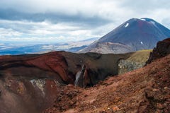 Ansicht des Bergs Ngauruhoe - Berg-Schicksal von alpiner Kreuzungswanderung Tongariro mit Wolken oben und rotem Krater im Vorderg lizenzfreies stockbild Ansicht des Bergs Ngauruhoe - Berg-Schicksal von alpiner Kreuzungswanderung Tongariro mit Wolken oben und rotem Krater im Vorderg lizenzfreies stockbild