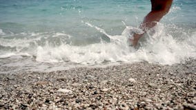 Ansicht des Strandes, auf dem die Füße des Mädchens durch die helle Seebrandung gewaschen werden stock video footage Ansicht des Strandes, auf dem die Füße des Mädchens durch die helle Seebrandung gewaschen werden stock video footage