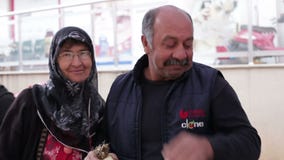 Antalya Turkiet - mars 2016: En man och en kvinna står le och omfamna, mannen som rymmer en packe av grönsallat stock video Antalya Turkiet - mars 2016: En man och en kvinna står le och omfamna, mannen som rymmer en packe av grönsallat stock video