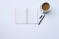 Anteckningsboken, pennan och kaffe rånar förlagt på ett vitt skrivbord i kontoret arkivbilder Anteckningsboken, pennan och kaffe rånar förlagt på ett vitt skrivbord i kontoret arkivbilder