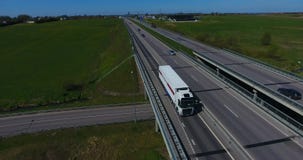 ANTENNE: Vrachtvrachtwagen die ladingscontainer op een weg vervoeren ANTENNE: Vrachtvrachtwagen die ladingscontainer op een weg vervoeren