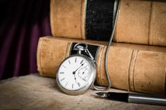 Antike Taschenuhr auf burled Holz mit alten ledernen gebundenen Büchern und Füllfederhalter lizenzfreie stockbilder Antike Taschenuhr auf burled Holz mit alten ledernen gebundenen Büchern und Füllfederhalter lizenzfreie stockbilder