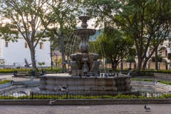 ANTÍGUA, GUATEMALA - 11 DE NOVEMBRO DE 2017: Pomba e fonte de voo no Central Park em Antígua, Guatemala Antígua é uma cidade pequ fotografia de stock ANTÍGUA, GUATEMALA - 11 DE NOVEMBRO DE 2017: Pomba e fonte de voo no Central Park em Antígua, Guatemala Antígua é uma cidade pequ fotografia de stock
