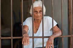 Anziana dietro le barre fotografia stock libera da diritti Anziana dietro le barre fotografia stock libera da diritti