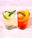 Apelsin- och elderflowercoctailar på vit träbakgrund royaltyfri foto Apelsin- och elderflowercoctailar på vit träbakgrund royaltyfri foto