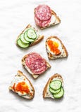 Appetizer sandwiches with red caviar, egg, sausage, cucumber and cream cheese on white background stock images Appetizer sandwiches with red caviar, egg, sausage, cucumber and cream cheese on white background stock images
