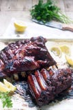 Appetizing baked glazed veal or pork ribs served with lemon and herbs. stock images Appetizing baked glazed veal or pork ribs served with lemon and herbs. stock images