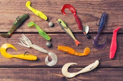 Appâts de silicone coloré avec des plombs sur la table en bois Image et vue supérieure modifiées la tonalité image libre de droits Appâts de silicone coloré avec des plombs sur la table en bois Image et vue supérieure modifiées la tonalité image libre de droits