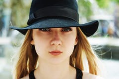 Apra il ritratto di una giovane donna in un primo piano del cappello fotografie stock libere da diritti Apra il ritratto di una giovane donna in un primo piano del cappello fotografie stock libere da diritti