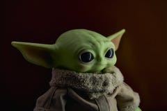 April, 2021: Head of baby Grogu, baby Yoda close-up. Realistic toy. Dark background