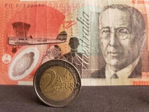 aproximação a uma moeda europeia de dois euro e fundo com a cédula australiana de vinte dólares fotografia de stock royalty free aproximação a uma moeda europeia de dois euro e fundo com a cédula australiana de vinte dólares fotografia de stock royalty free