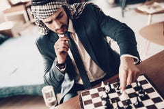 Arab businessman playing chess and ponders move royalty free stock photo Arab businessman playing chess and ponders move royalty free stock photo