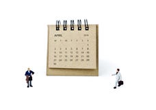 arachnids Calendar лист и миниатюрные пластичные бизнесмены на белизне стоковое фото arachnids Calendar лист и миниатюрные пластичные бизнесмены на белизне стоковое фото