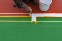 Arbeider die de nevenactiviteit op de vloer voor openluchtstadion schilderen Royalty-vrije Stock Afbeelding Arbeider die de nevenactiviteit op de vloer voor openluchtstadion schilderen Royalty-vrije Stock Afbeelding