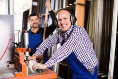 Arbeiders die vensterprofielen snijden stock foto's Arbeiders die vensterprofielen snijden stock foto's