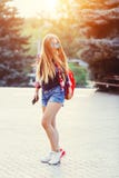 Arbeiten Sie Porträt der jungen hübschen Hippie-Frau um, die mit dem langen Haar und rotem Rucksack in der sonnigen Sommerstraße lizenzfreies stockfoto Arbeiten Sie Porträt der jungen hübschen Hippie-Frau um, die mit dem langen Haar und rotem Rucksack in der sonnigen Sommerstraße lizenzfreies stockfoto