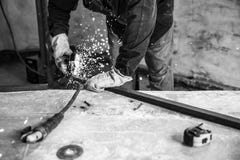 Arbeitskraftausschnitt-Metallprofil mit elektrischem Winkelschleifer Leute bei der Arbeit, Beruf Einfarbiger Effekt stockfotografie Arbeitskraftausschnitt-Metallprofil mit elektrischem Winkelschleifer Leute bei der Arbeit, Beruf Einfarbiger Effekt stockfotografie