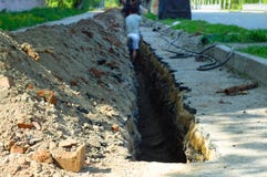 Arbeitskräfte graben ein Loch im Asphalt auf Fußgängerabschnitt lizenzfreies stockbild Arbeitskräfte graben ein Loch im Asphalt auf Fußgängerabschnitt lizenzfreies stockbild