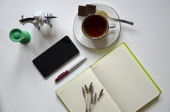 Arbeitsplatz mit Notizblock, Tasse Tee auf einem wei?en Hintergrund Flache Lage, Draufsichtschreibtischschreibtisch Arbeitsplatzf lizenzfreie stockfotografie Arbeitsplatz mit Notizblock, Tasse Tee auf einem wei?en Hintergrund Flache Lage, Draufsichtschreibtischschreibtisch Arbeitsplatzf lizenzfreie stockfotografie