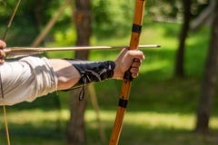 Archer Hand Holds His Bow With An Arrow And Aiming At The Target Royalty Free Stock Photos