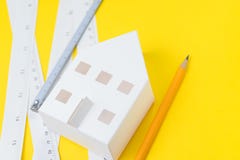 Architecture design tools or project plan for building house concept, selective focus on white paper craft house with windows and stock images Architecture design tools or project plan for building house concept, selective focus on white paper craft house with windows and stock images