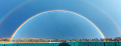 Arco iris lleno hermoso sobre campo de granja en la primavera imagenes de archivo Arco iris lleno hermoso sobre campo de granja en la primavera imagenes de archivo
