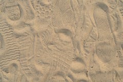 Areia na praia com pegadas e sapatas Muitas pegadas com sapatas e sem sapatas imagem de stock Areia na praia com pegadas e sapatas Muitas pegadas com sapatas e sem sapatas imagem de stock