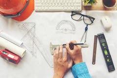 Arkitekt f?r b?sta sikt som arbetar p? ritning Arkitektarbetsplats Teknikerhj?lpmedel och s?kerhetskontroll, ritningar, linjal, o royaltyfria foton Arkitekt f?r b?sta sikt som arbetar p? ritning Arkitektarbetsplats Teknikerhj?lpmedel och s?kerhetskontroll, ritningar, linjal, o royaltyfria foton