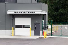 Armazene o transporte da construção que recebe a porta da garagem e bloqueie-o com entrada de automóveis da estrada fotografia de stock Armazene o transporte da construção que recebe a porta da garagem e bloqueie-o com entrada de automóveis da estrada fotografia de stock